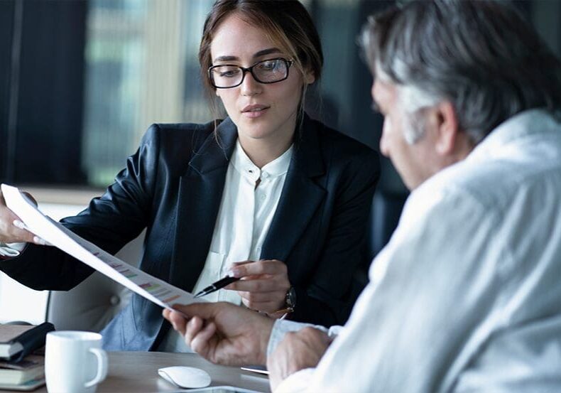 Businesswoman explaining document to client.