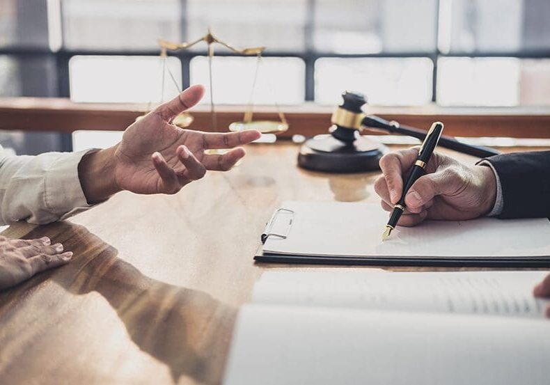 Lawyer signing legal document with client.