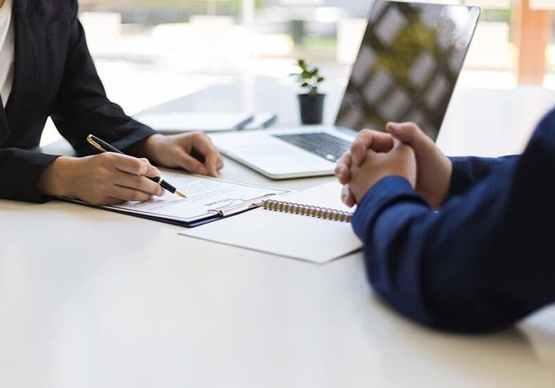 Businesswoman signing document with client.